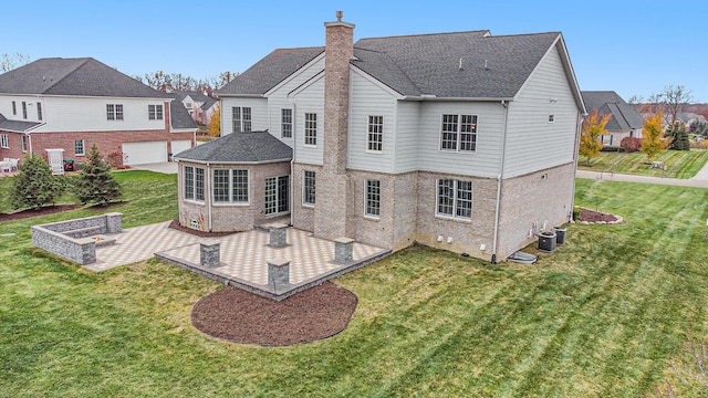 rear view of house featuring a lawn, cooling unit, a garage, and a patio