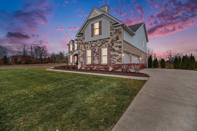 property exterior at dusk with a lawn and a garage