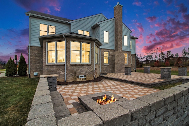 back house at dusk with a patio area and an outdoor fire pit