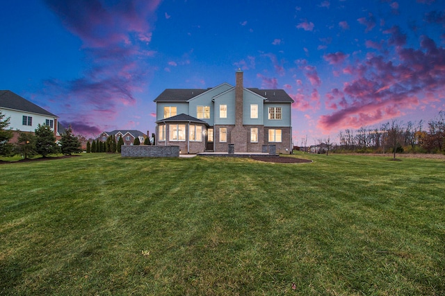 back house at dusk with a yard