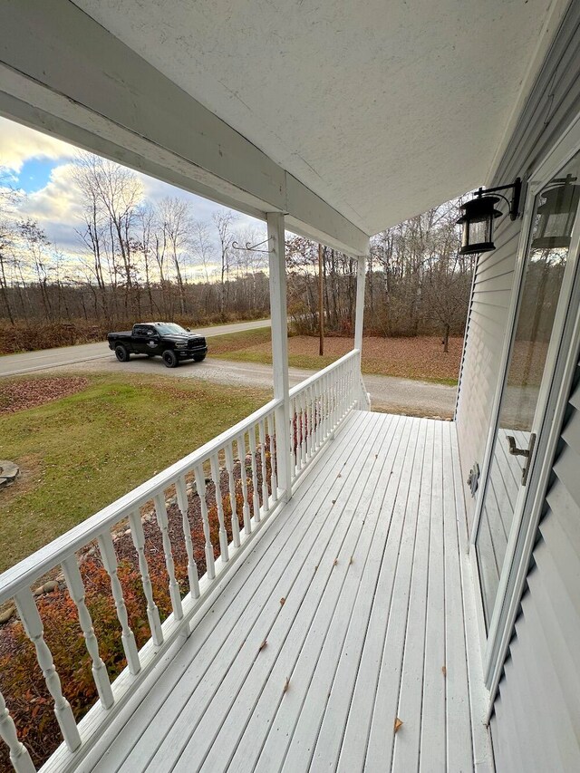 wooden deck featuring a yard and covered porch