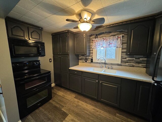 kitchen with hardwood / wood-style floors, sink, black appliances, and tasteful backsplash