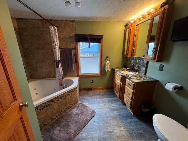 full bathroom featuring shower / bath combination with curtain, a textured ceiling, hardwood / wood-style floors, vanity, and toilet