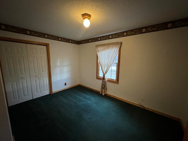 unfurnished bedroom with carpet, a textured ceiling, and a closet