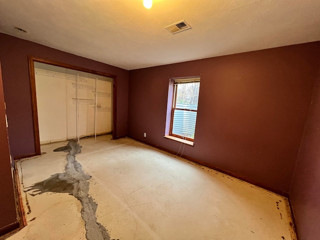 unfurnished bedroom featuring a textured ceiling and a closet