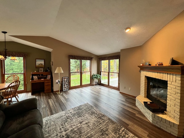 living room with a textured ceiling, a fireplace, dark wood-type flooring, and lofted ceiling