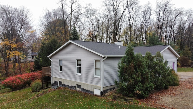 view of side of home featuring a lawn and a deck