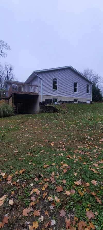 view of home's exterior featuring a wooden deck and a lawn