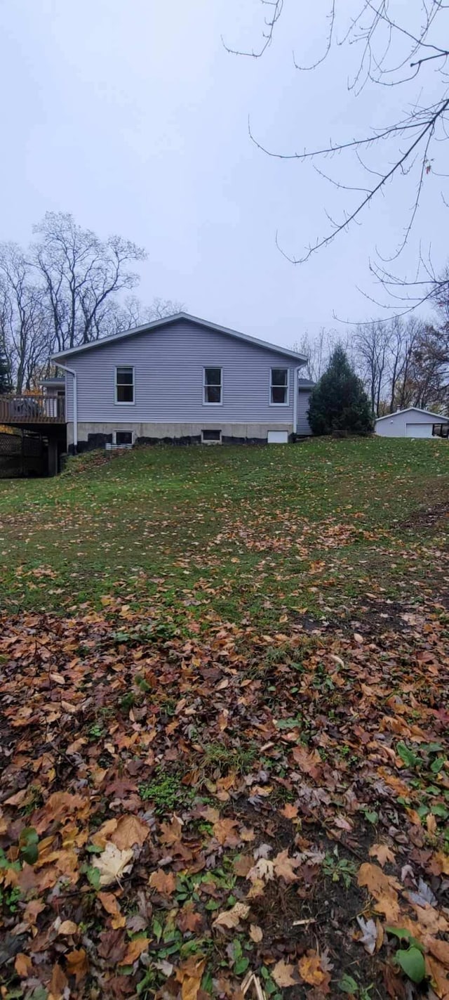 view of side of home with a yard and a deck