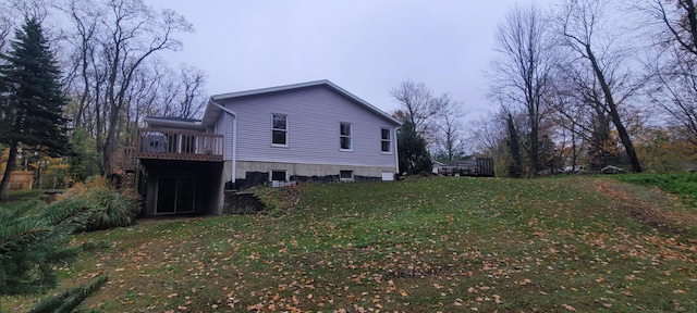 view of side of home with a yard and a wooden deck