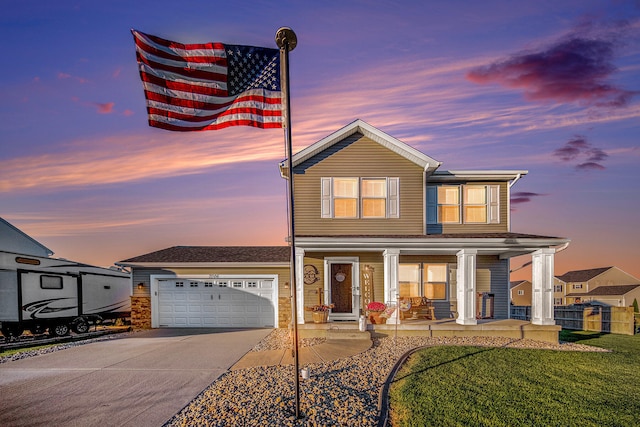 view of front of home featuring a garage, a yard, and covered porch