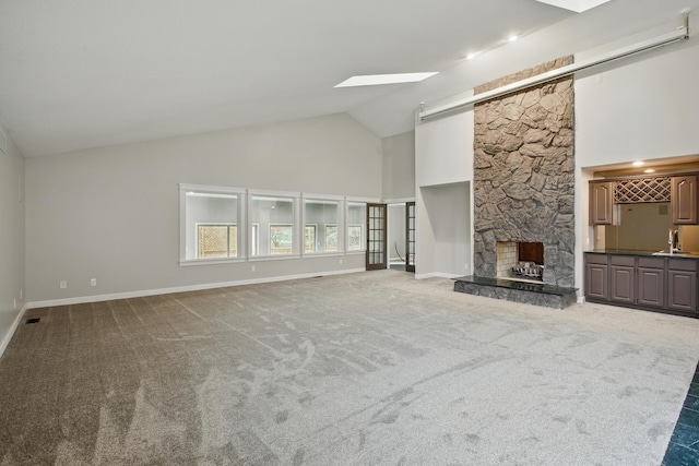 4489 Cranbrook Trl, Orchard Lake, MI 48323 - unfurnished living room featuring high vaulted ceiling, a stone fireplace, carpet floors, a sink, and baseboards