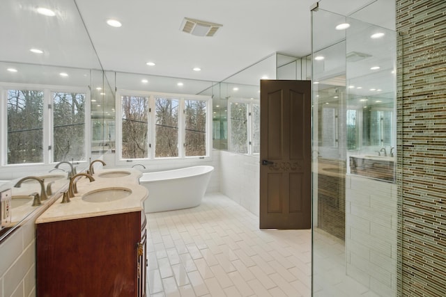 4489 Cranbrook Trl, Orchard Lake, MI 48323 - full bath featuring a freestanding tub, a shower stall, visible vents, tile walls, and a sink