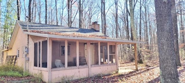 view of property exterior with a sunroom