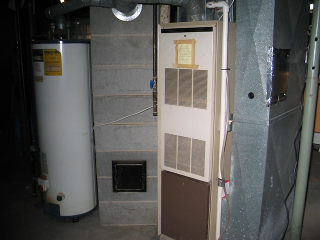 utility room featuring heating unit and gas water heater