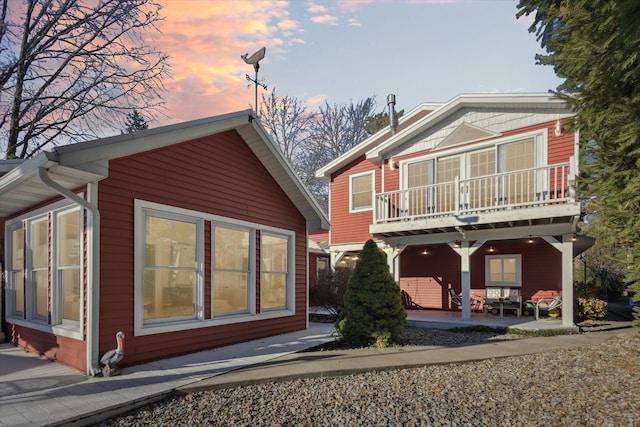 back house at dusk with a balcony