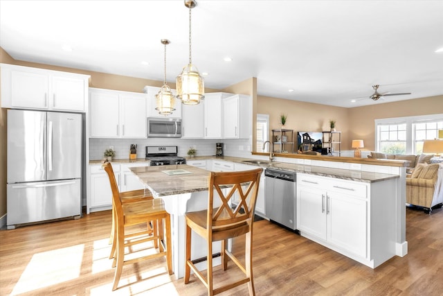 kitchen featuring white cabinets, kitchen peninsula, sink, and stainless steel appliances