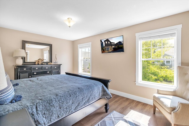 bedroom featuring hardwood / wood-style floors and multiple windows