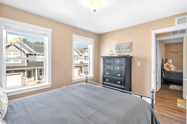 bedroom with dark wood-type flooring and multiple windows