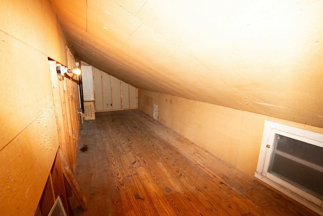 additional living space with hardwood / wood-style flooring and vaulted ceiling