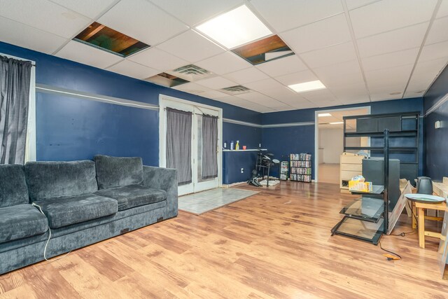 living room with hardwood / wood-style floors and a drop ceiling