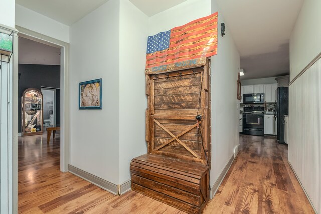 corridor with hardwood / wood-style floors