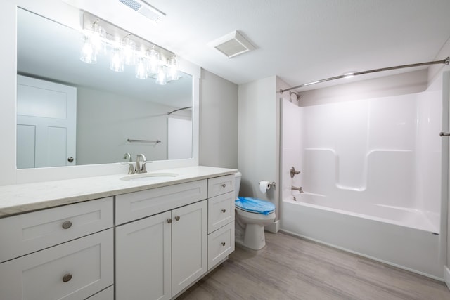 full bathroom with hardwood / wood-style floors, vanity, shower / bathtub combination, and toilet