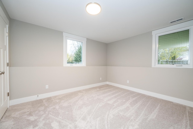 spare room featuring light carpet and lofted ceiling