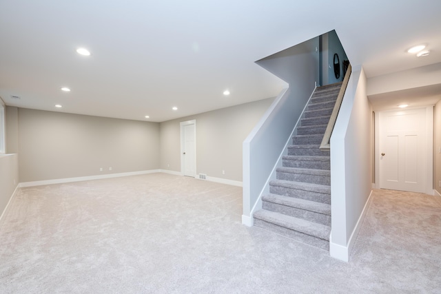 basement featuring light colored carpet