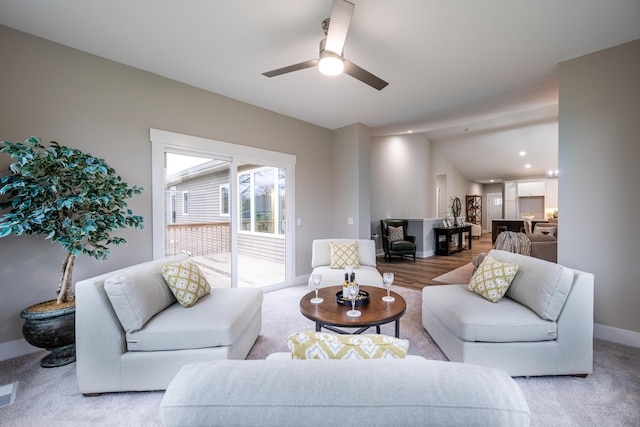 living room featuring ceiling fan, light hardwood / wood-style floors, and lofted ceiling