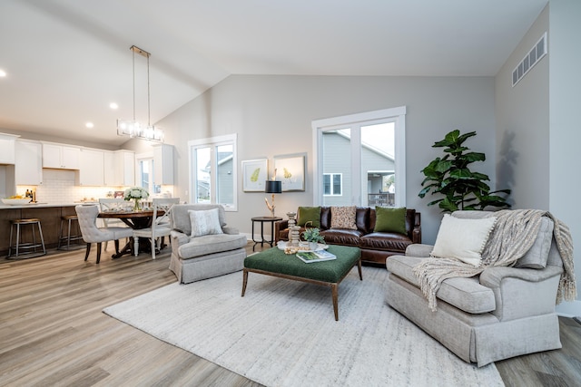 living room with vaulted ceiling and light wood-type flooring