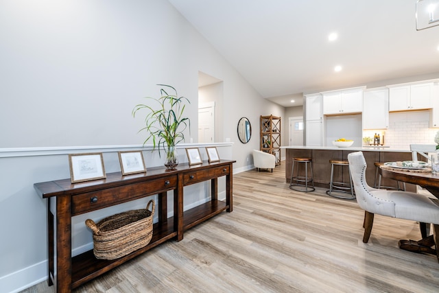 interior space featuring light hardwood / wood-style floors and vaulted ceiling