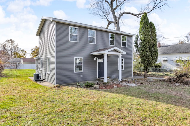 view of front of house with central AC unit and a front yard