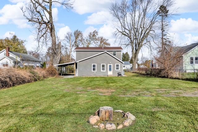 back of house featuring a carport and a lawn