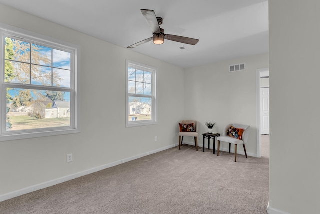 sitting room featuring ceiling fan, carpet floors, and a healthy amount of sunlight