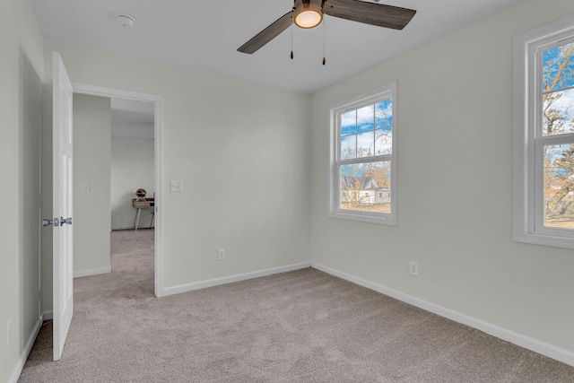 empty room featuring light colored carpet, plenty of natural light, and ceiling fan