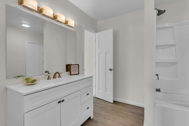 bathroom with hardwood / wood-style floors, vanity, and walk in shower