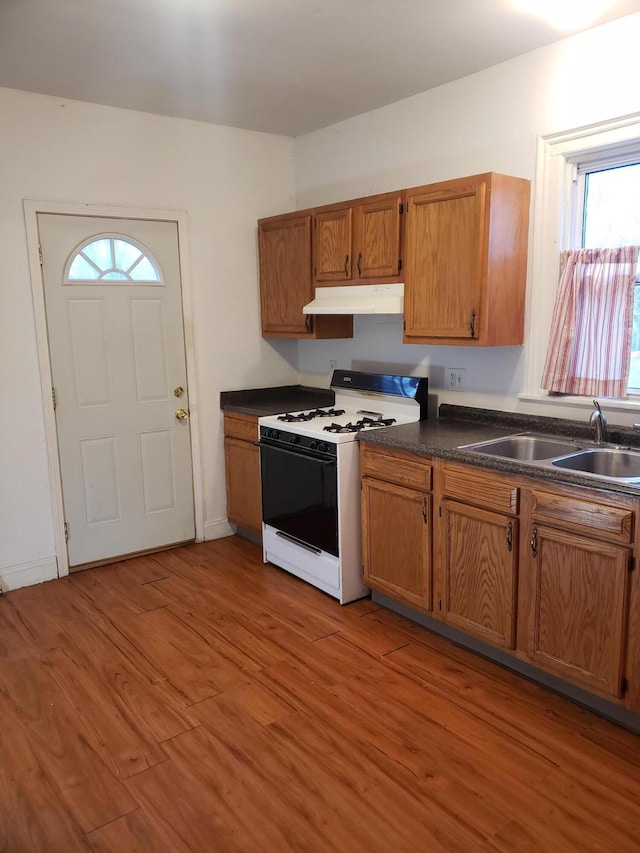 kitchen featuring gas range gas stove, sink, plenty of natural light, and light wood-type flooring