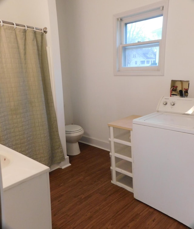 bathroom featuring hardwood / wood-style flooring, toilet, and washer / dryer