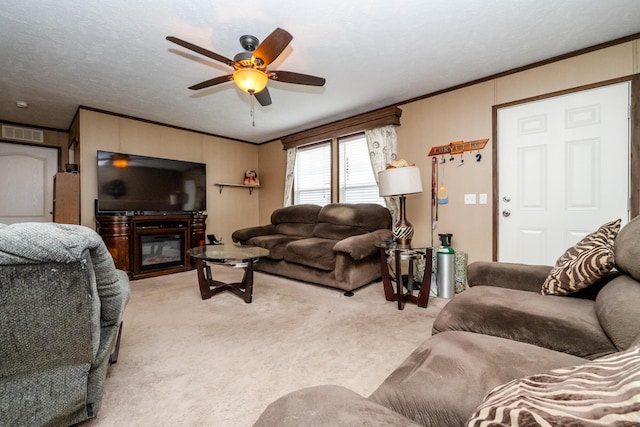 carpeted living room with ceiling fan, ornamental molding, and a textured ceiling