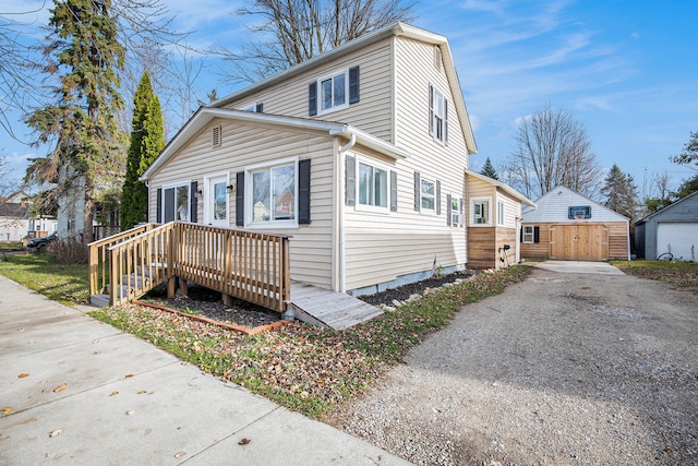 view of property with a garage and a storage unit