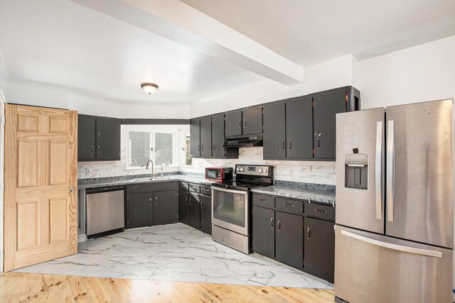 kitchen with stainless steel appliances, tasteful backsplash, light hardwood / wood-style floors, and sink