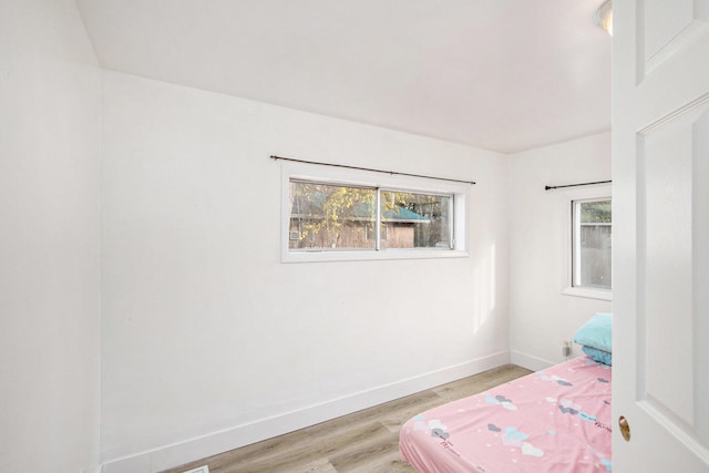 bedroom featuring light hardwood / wood-style flooring and multiple windows