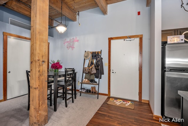 dining space featuring beam ceiling, hardwood / wood-style floors, and wooden ceiling