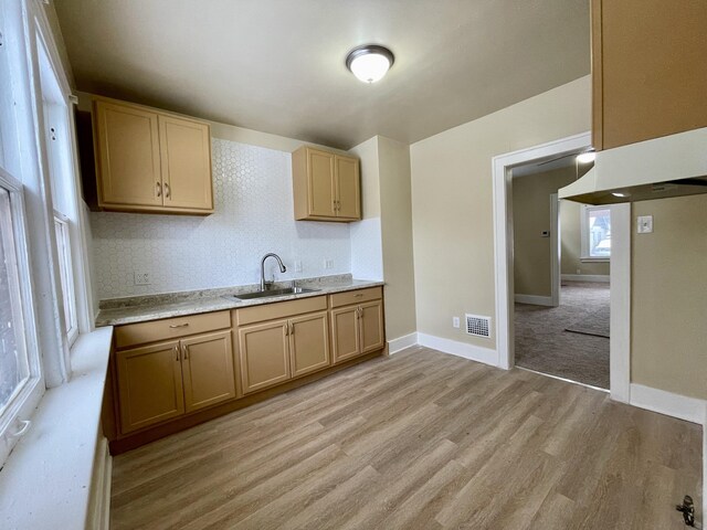 kitchen featuring light brown cabinetry, sink, and light wood-type flooring