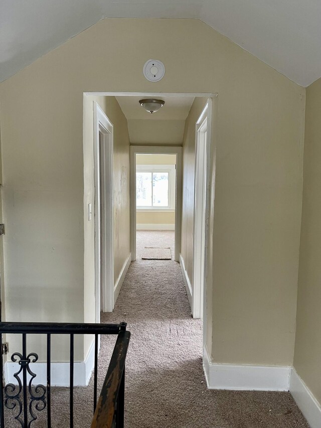 corridor featuring carpet floors and vaulted ceiling