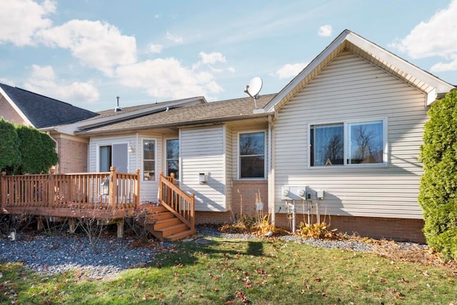 back of property with a lawn and a deck