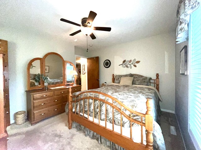 bedroom with a textured ceiling, ceiling fan, and light carpet