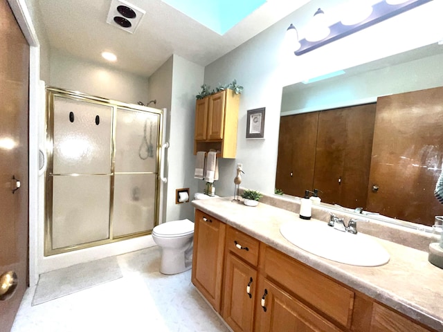 bathroom featuring toilet, vanity, and walk in shower