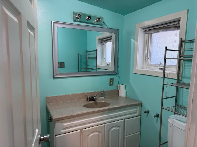 bathroom with a wealth of natural light, vanity, and toilet